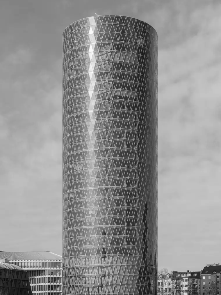 Runder Glasturm mit Rautenfassade am Mainufer, schwarz-weiß